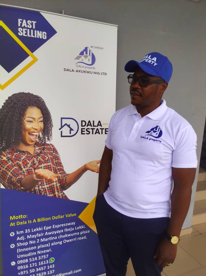 Dala Real Estate representative beside the company display